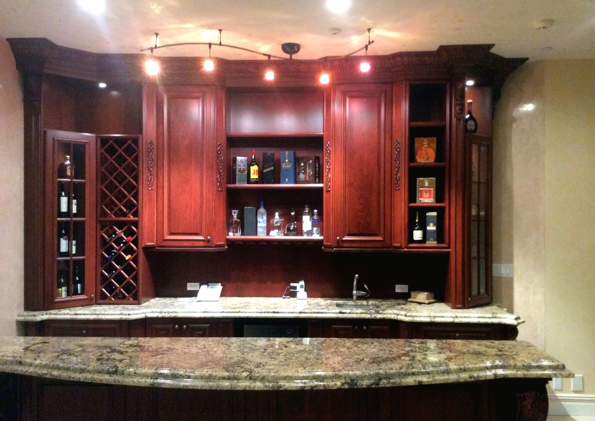 Custom home bar with wood cabinetry and stone countertop